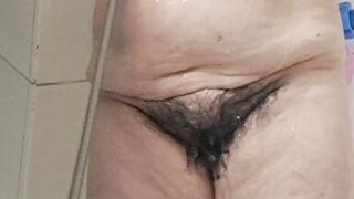 Mature milf bathing her tits and hairy pussy gets excited by the water